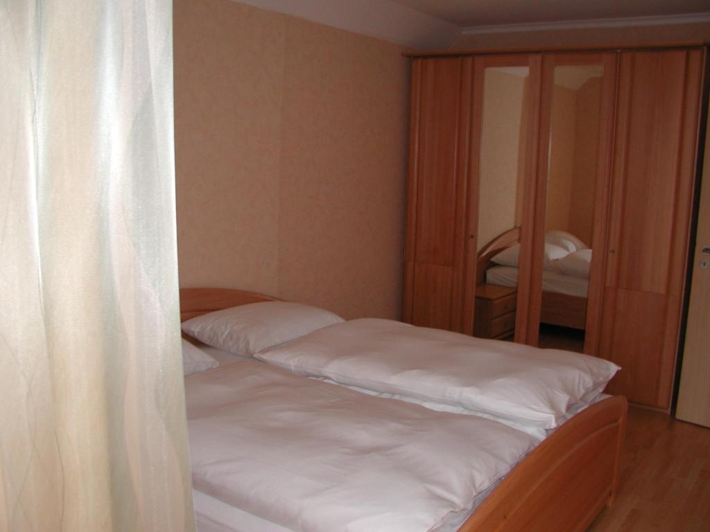 two beds in a small room with a mirror at Gästehaus in Kaltenengers