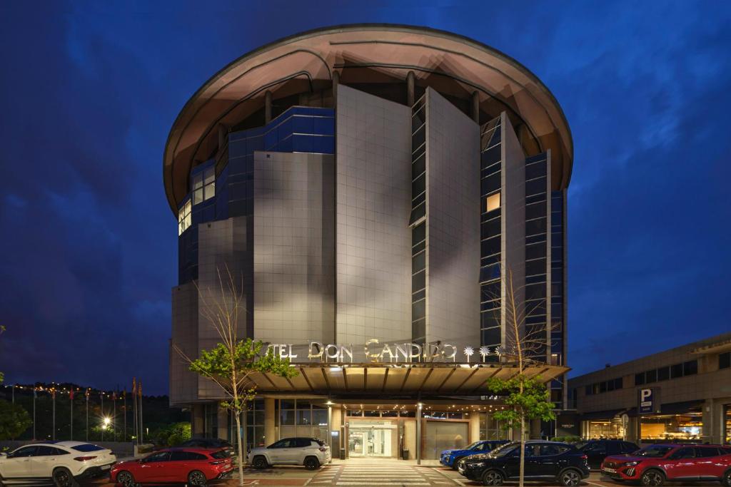 a building with cars parked in a parking lot at Eurostars Don Cándido in Terrassa
