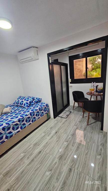 a bedroom with a bed and a desk and a table at Jolie Joes Standard Room with Private Bathroom in Tagudin