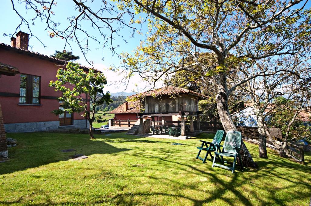 un patio con 2 sillas y una casa en Apartamentos el Cueto de los Collado, en Villanueva de Pría