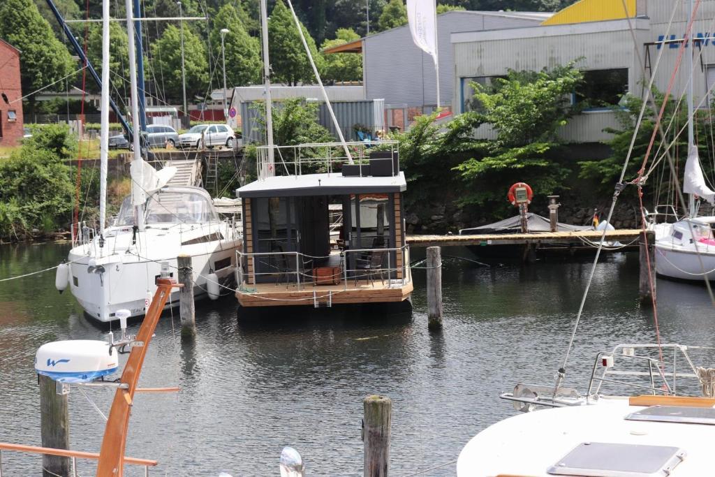 a small boat docked at a dock in the water at Houseboat Leni, Flensburg in Flensburg
