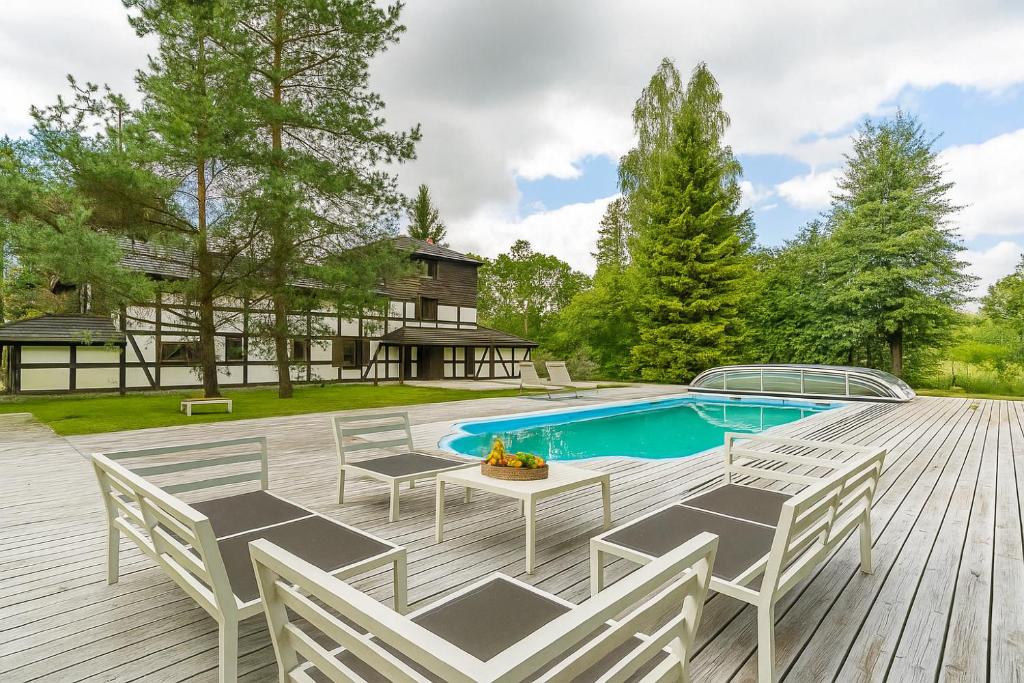 a deck with chairs and a swimming pool at Imperial Apartments - Villa Koleczkowo in Koleczkowo