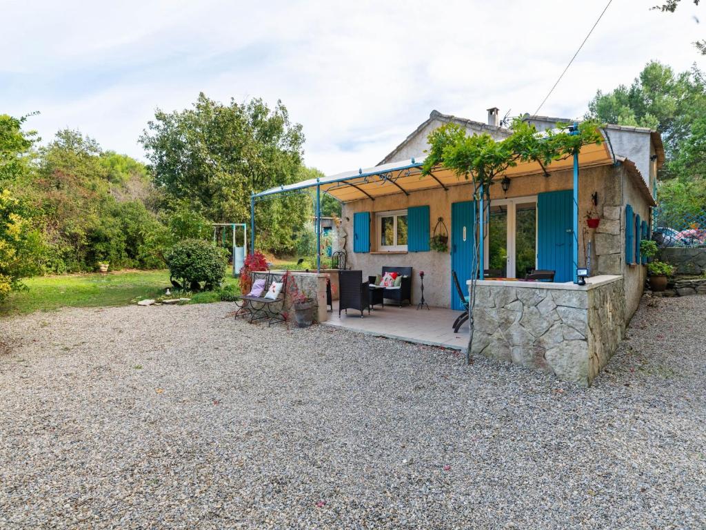 a small house with blue doors and a patio at Modern holiday home with private pool in Lambesc