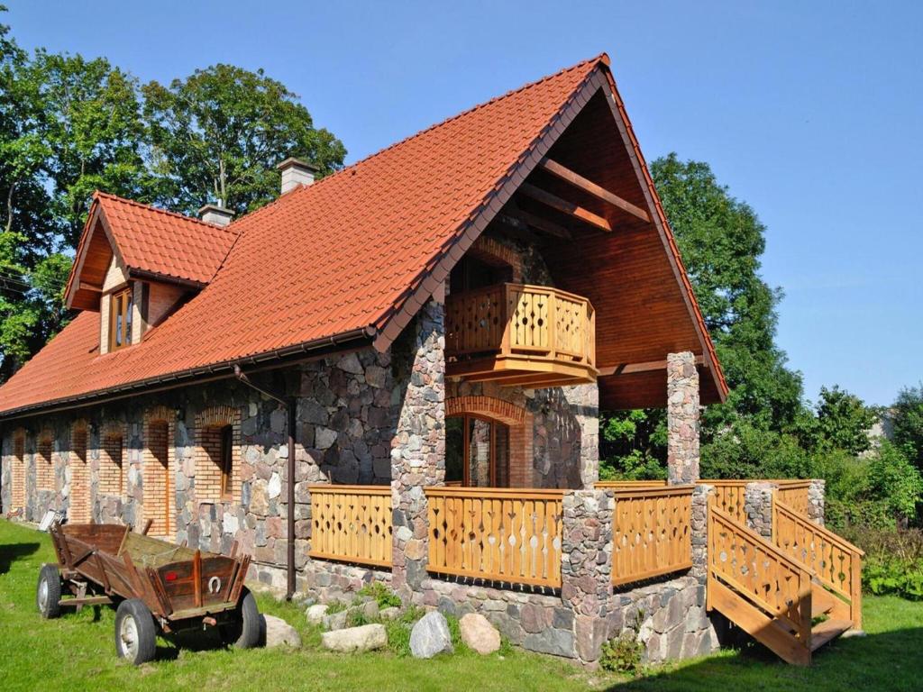 Una cabaña de troncos con techo naranja y un camión delante. en Comfortable holiday home, Grabczyn, en Grąbczyn