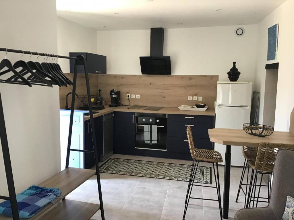 a kitchen with a stove and a table with chairs at Charmant studio Vias village in Vias