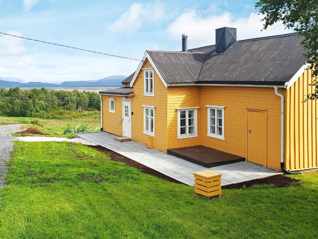 a small yellow house on a grass field at 7 person holiday home in Skutvik in Skutvika