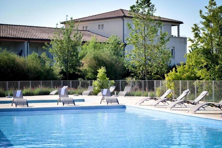 a group of lounge chairs and a swimming pool at Residence du Château de Jouarres, Azille - Studio 2 pers with balcony in Azille
