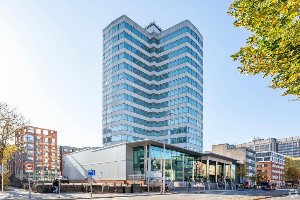 a tall glass building in a city at Holland House Hotel Cardiff By Sunday in Cardiff