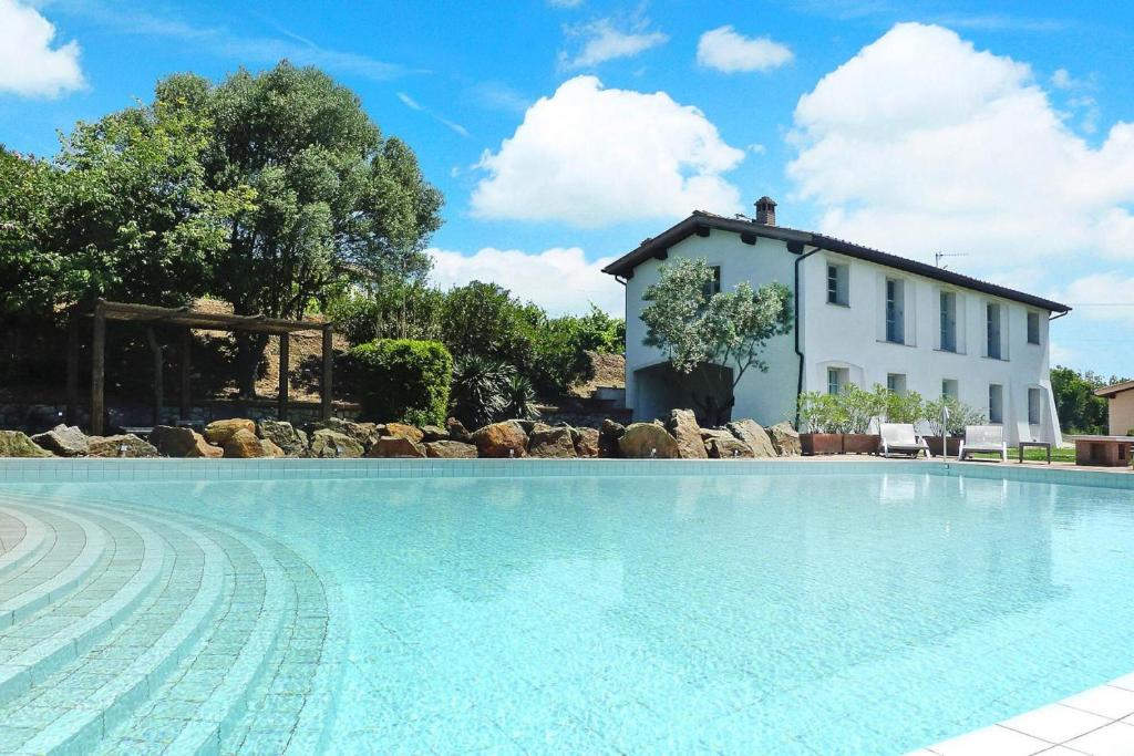 a villa with a swimming pool in front of a house at Residence La Chiusa di Rio, Rio nell'Elba in Rio nellʼElba