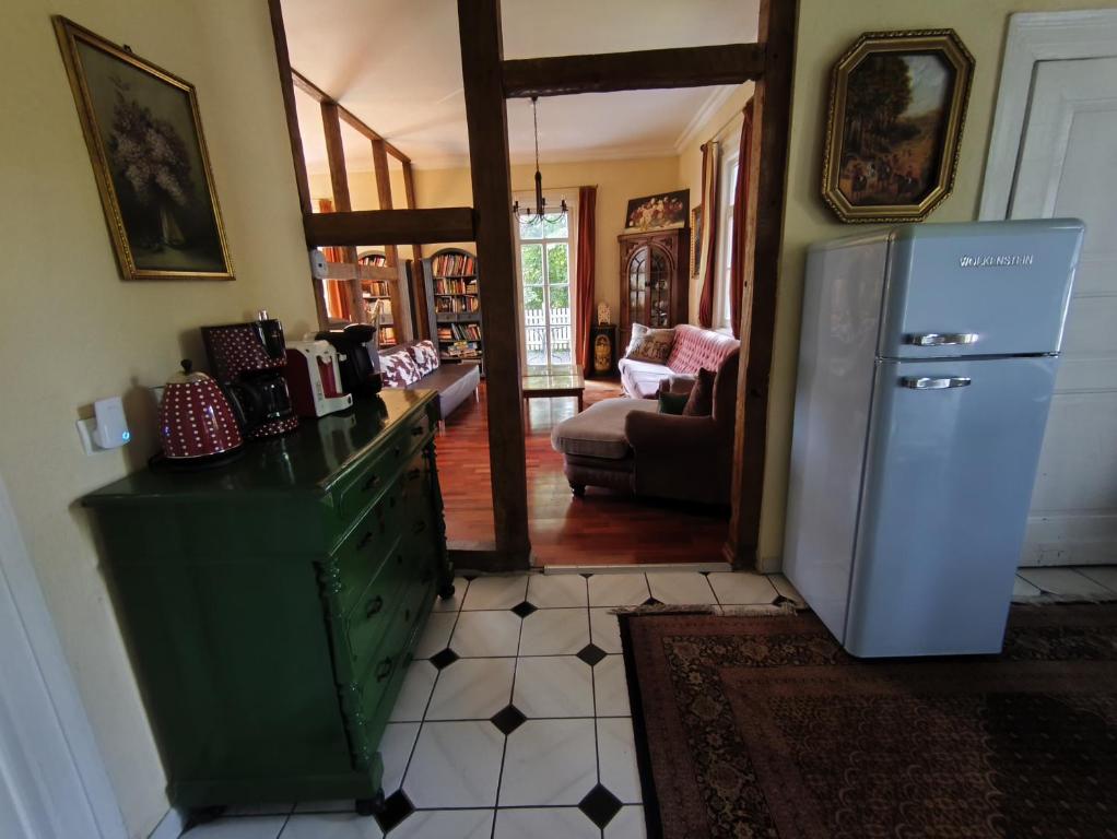 a kitchen with a refrigerator and a living room at Ferienhaus Dreamholiday - Stilvolles großes Ferienhaus mit Garten in Mittelhof