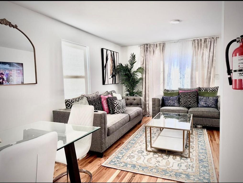 a living room with a couch and a table at Exquisite 3 KINGs bed 5 mins EWR airport 25 mins from NYC in Newark