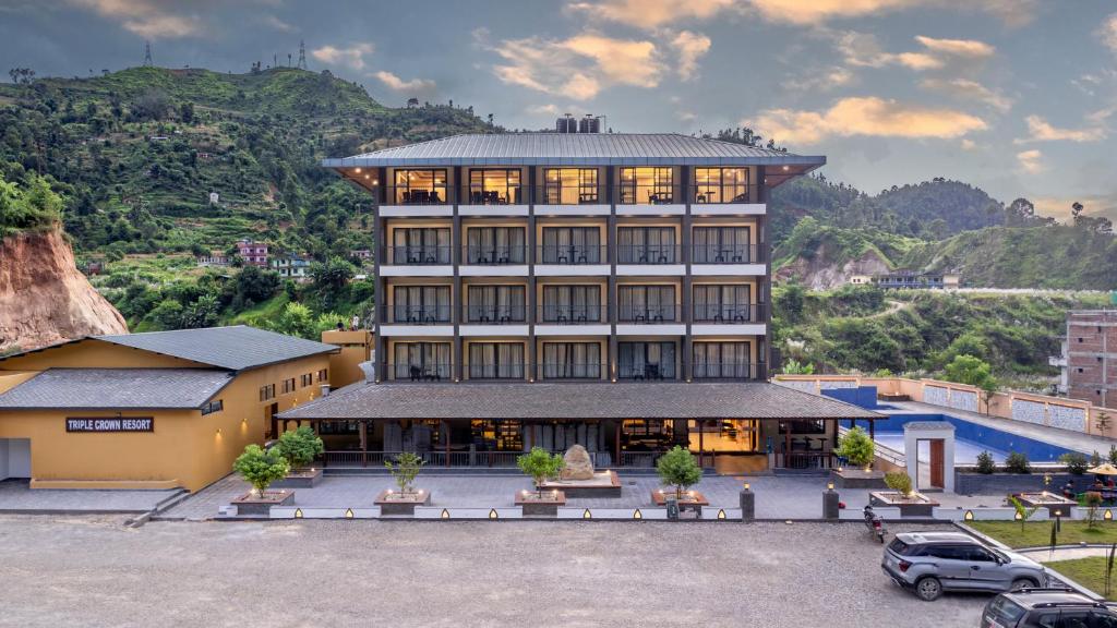 a large building with a car parked in front of it at Triple Crown Resort in Dhāding
