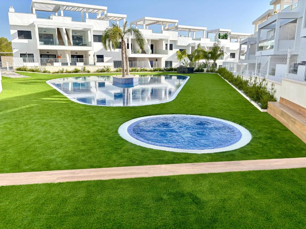 an image of a lawn with a fountain in front of a building at Casa Mia in Torrevieja