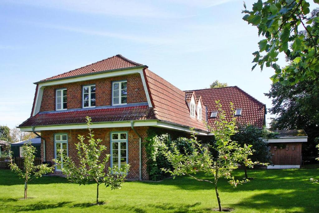 an old brick house with trees in the yard at Ferienwohnung im Gutshaus Schulenbrook in Metelsdorf