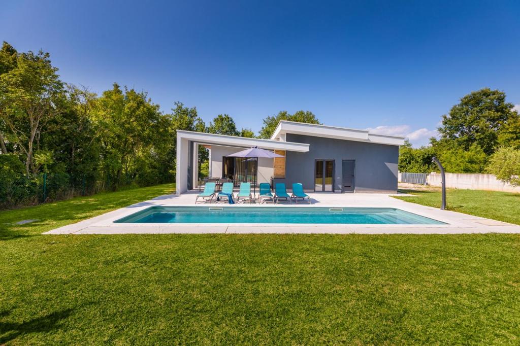 a house with a swimming pool in a yard at Villa Mariva in Žminj