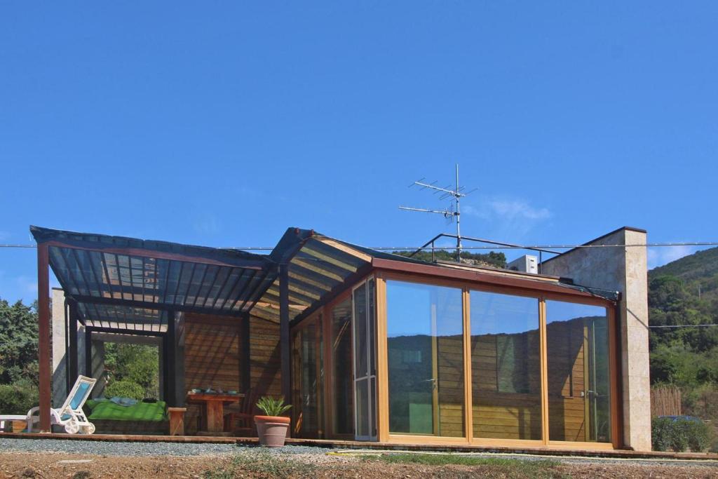 a glass extension of a house with a roof at Holiday home Biocasa Fabiana, Portoferraio Magazzini in SantʼAnna