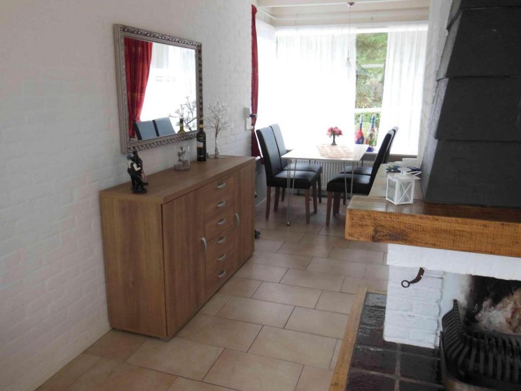 a living room with a mirror on top of a dresser at Pretty home in Sint Maartenszee in Sint Maartenszee