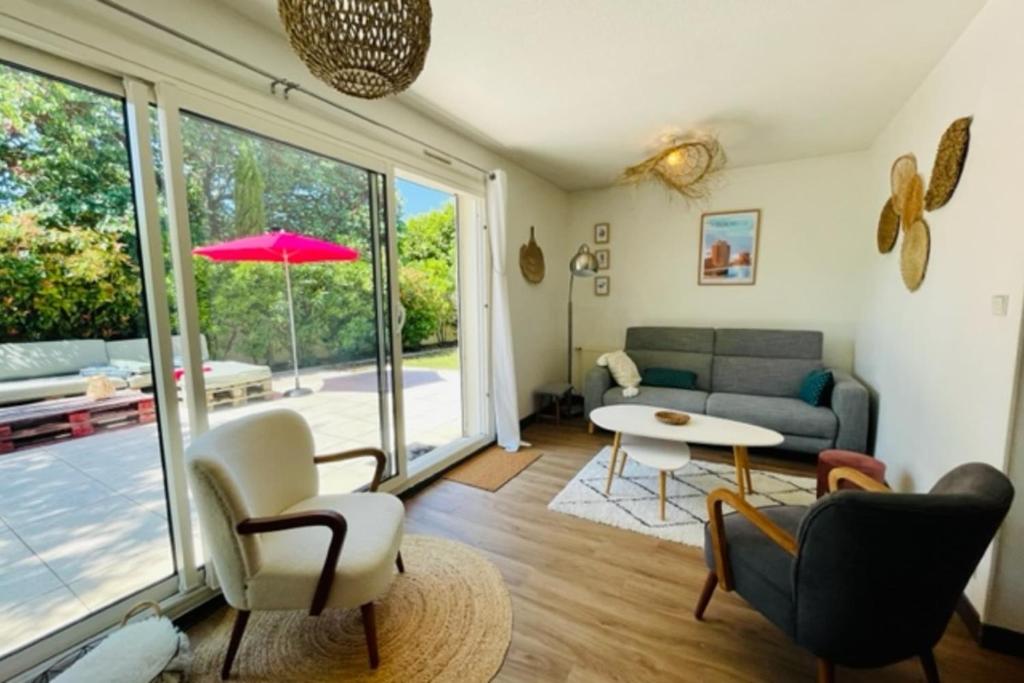 a living room with a couch and a table at Spacious cocoon with pool in La Rochelle in La Rochelle