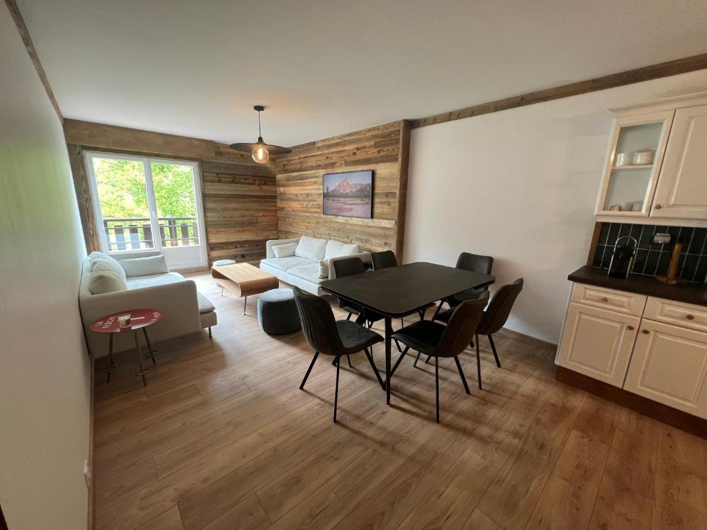 un salon avec une table, des chaises et un canapé dans l'établissement Bel appartement Samoëns 72m2, à Samoëns