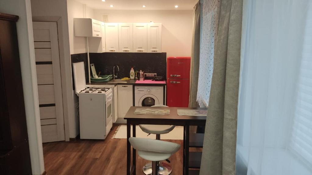 una piccola cucina con tavolo e frigorifero rosso di Studio Apartment a Narva