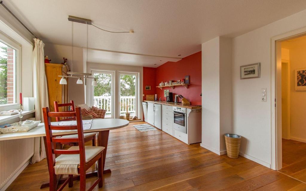a kitchen with red walls and a table and chairs at Strandmatte in Böhl