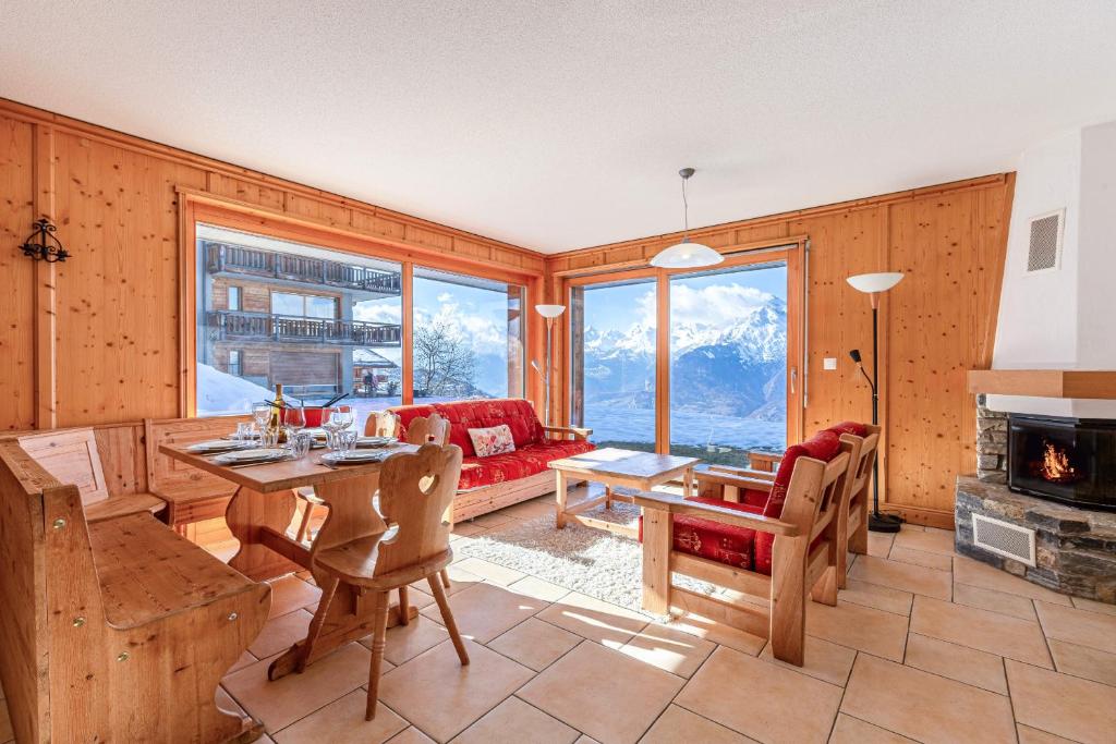 una sala de estar con una mesa y una chimenea en Plein Ciel VA 013 - MOUNTAIN apartment 8 pers, en Veysonnaz