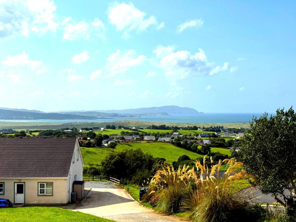 a house on a hill with a view of the ocean at Heather View Cottage in Carrigart