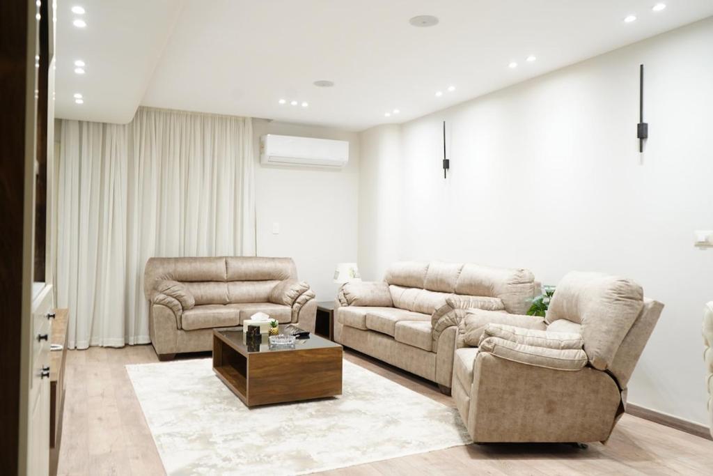 a living room with two couches and a coffee table at kornfil guest house in New cairo