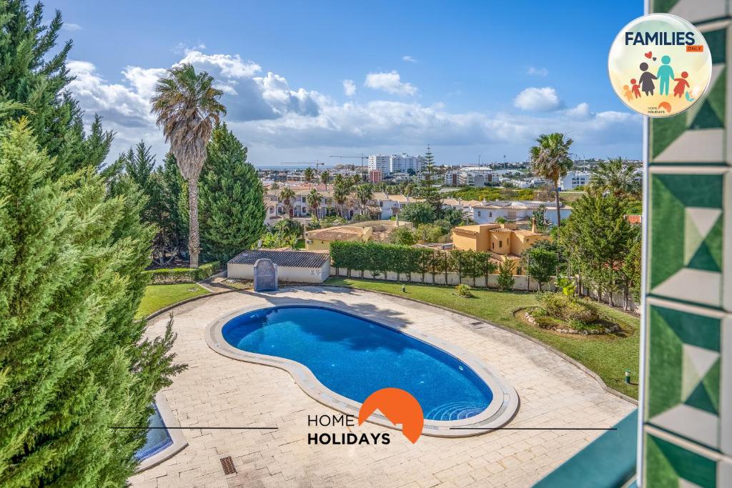 a villa with a swimming pool and a palm tree at #201 Families Only - Quinta da Flor in Vale de Pedras