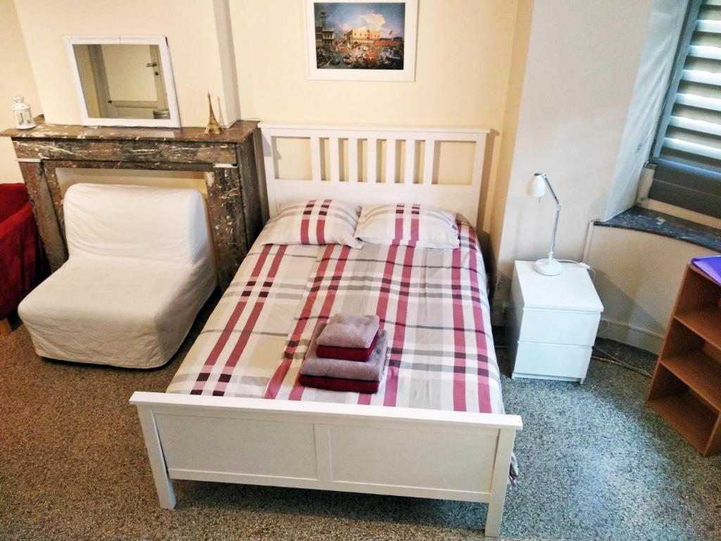 a bedroom with a bed with a plaid blanket at Central and convenient studio near supermarkets and public transports in Brussels