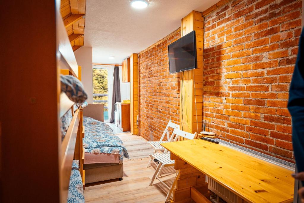 a living room with a brick wall and a table at STD Stara Vodenica in Crni Vrh