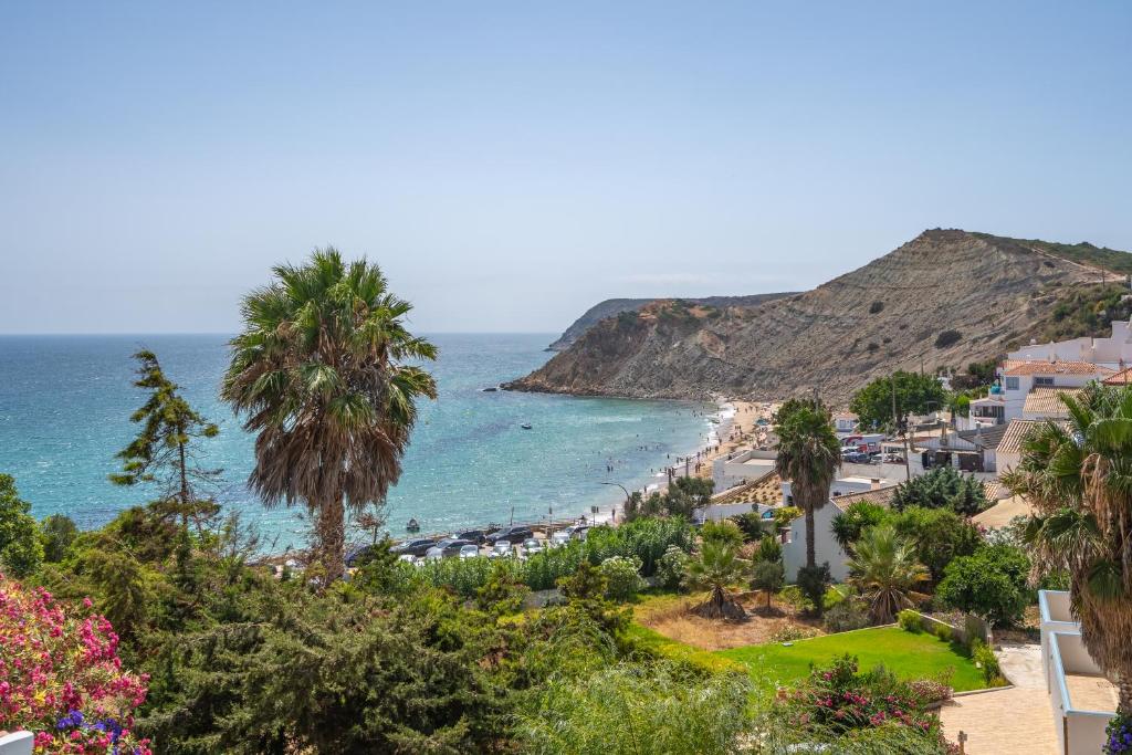 Una vista de una playa con palmeras y el océano. en Stunning sea view apartment in Burgau #1897, en Burgau