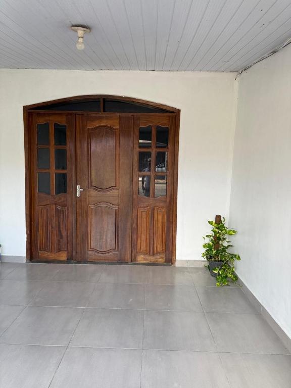 a large wooden door in a room with a plant at Pedro Teixeira House in Belém