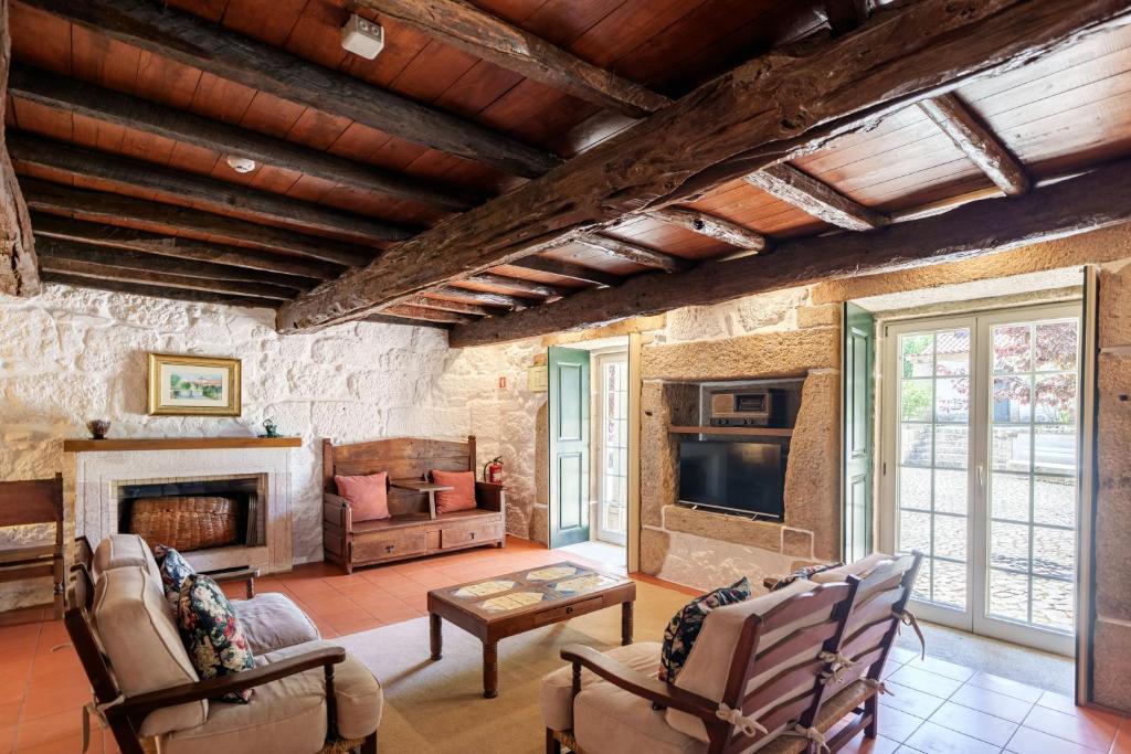 ein Wohnzimmer mit Kamin und Fernseher in der Unterkunft Feel Discovery Casa Da Capela Douro Valley in Armamar