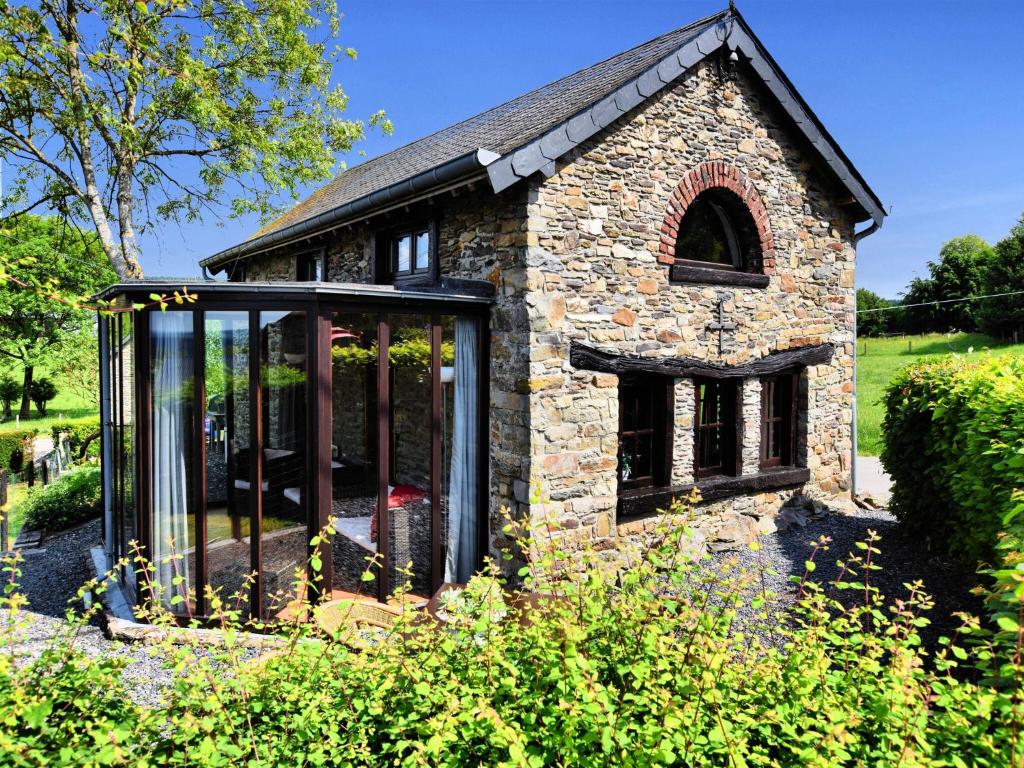 an extension to a stone house with glass doors at Romantic holiday house in the Ardennes in Nadrin