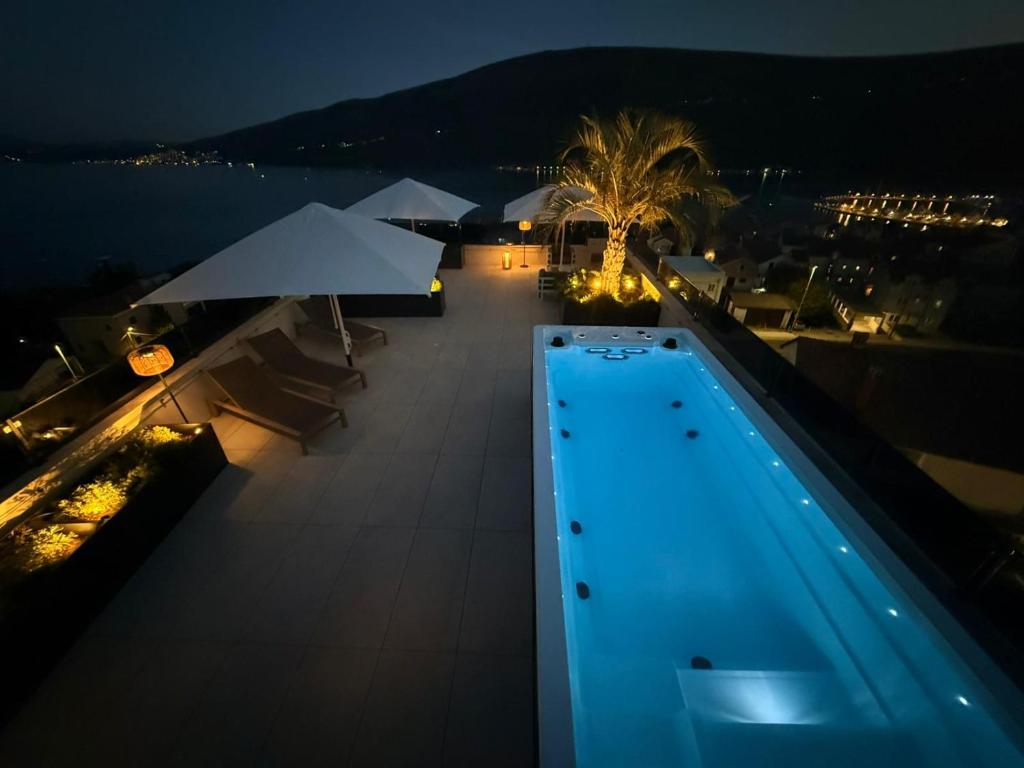 KravljaPenthouse Apartment mit Meerblick in der Bucht von Kotor mit Pool Area- 400m bis zum Strand的游泳池的夜景