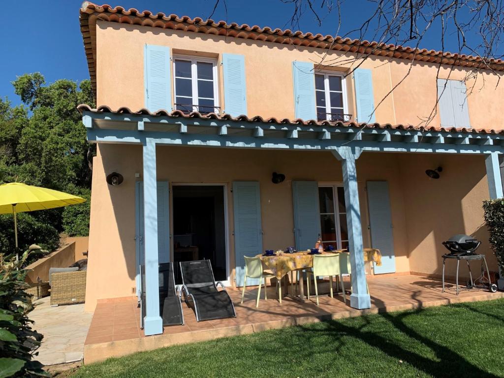 a house with a table and chairs on a patio at Family-Friendly Villa with Pool in La Garonnette-Plage