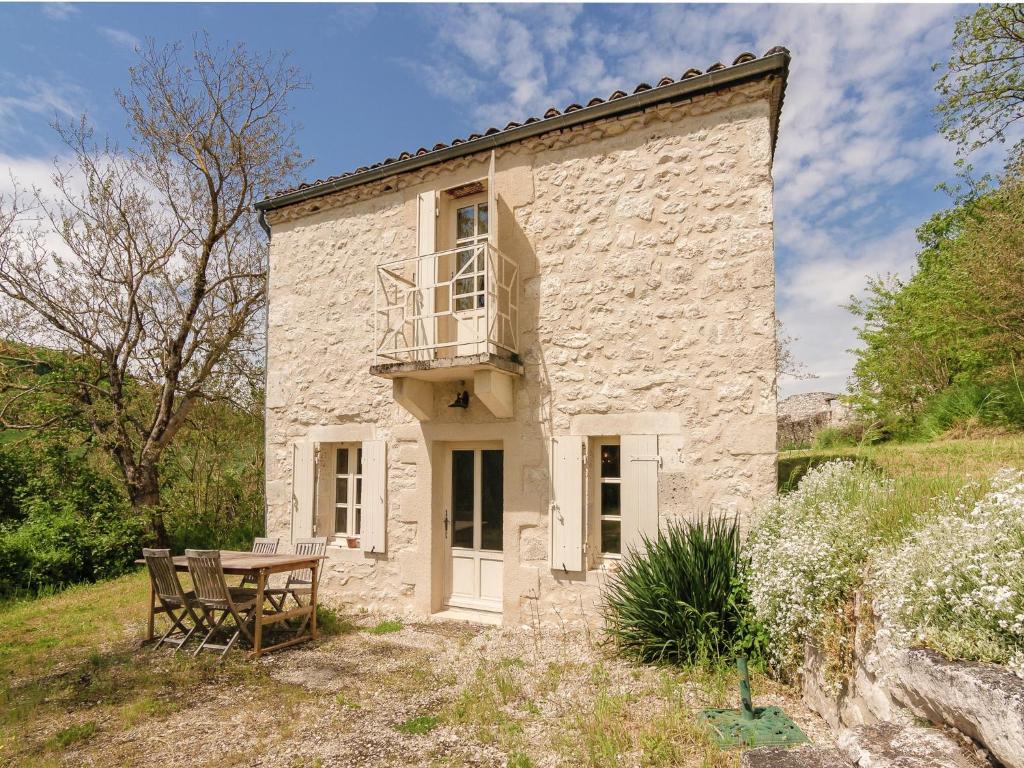 una casa in pietra con tavolo e balcone di Cottage in Wine Country a Anthé