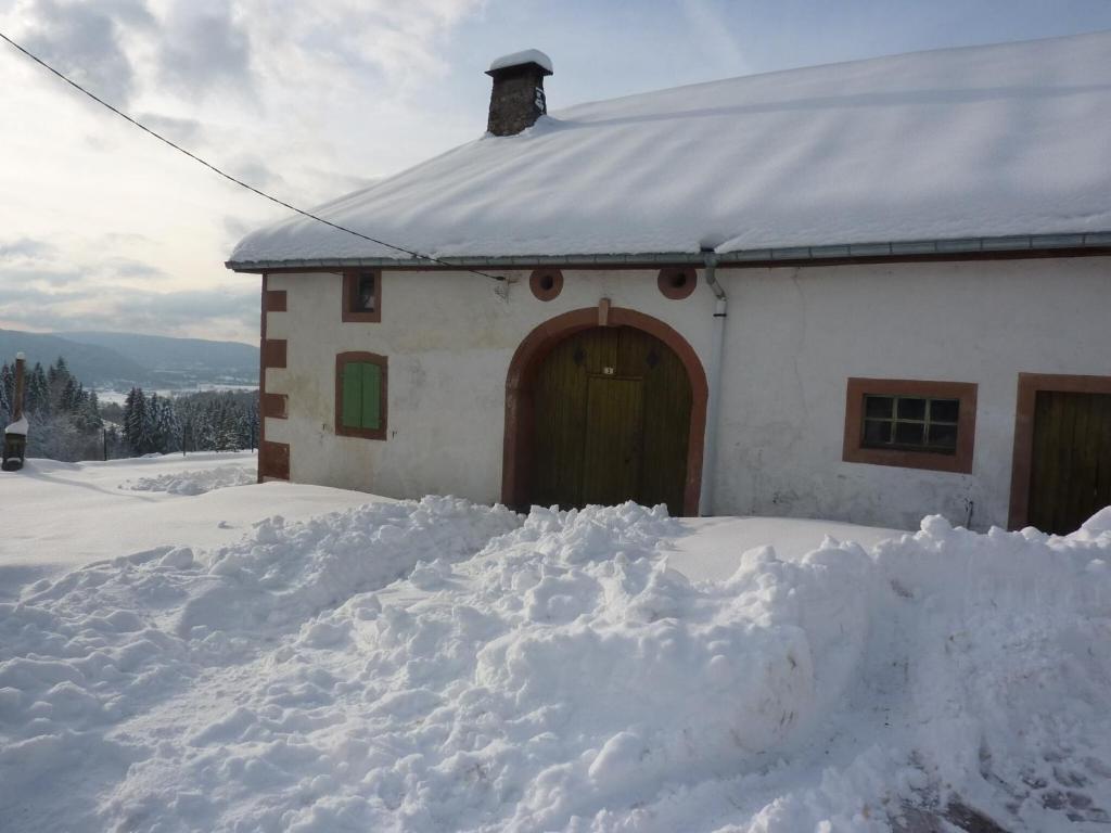 a house with a pile of snow in front of it at Holiday Home Vagney near Ski Gérardmer in Vagney