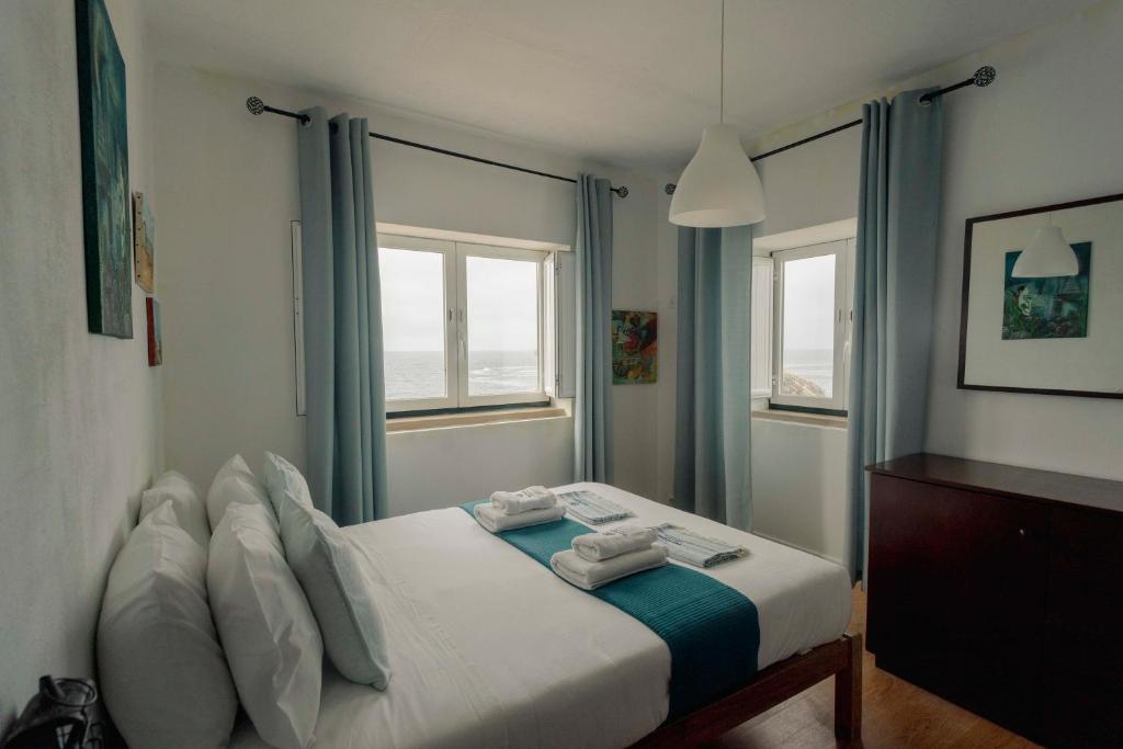 a bedroom with a bed with towels on it at Best Houses 51 - Casa das Marés I - Berlenga in Ferrel