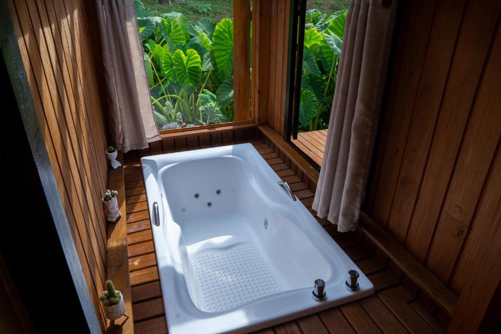 eine Badewanne in einem Raum mit Fenster in der Unterkunft Cabana Haere Tonu- Seu Refúgio no Coração do Vale Europeu in Benedito Novo