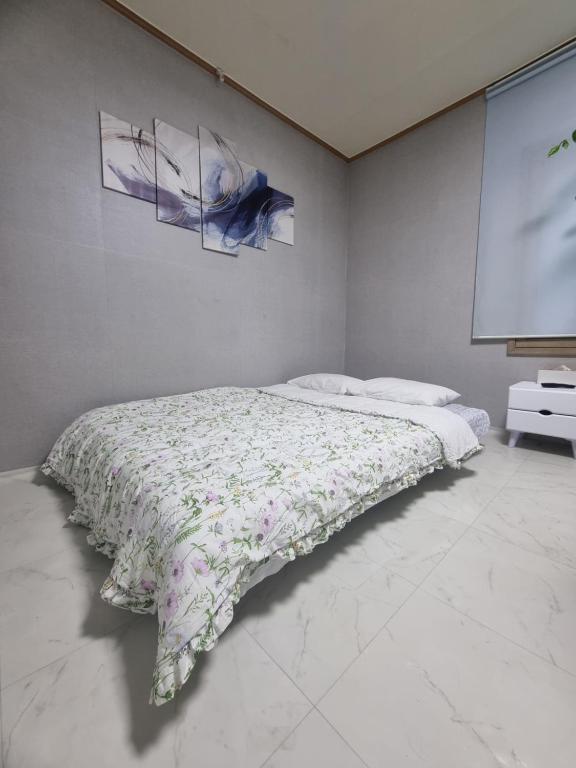 a bedroom with a bed with a blanket on it at Lucky House in Busan
