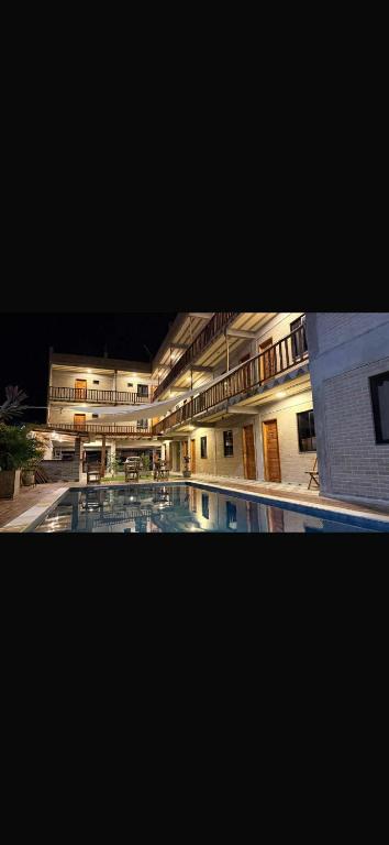 a large building with a swimming pool at night at pousada calango in Aracati