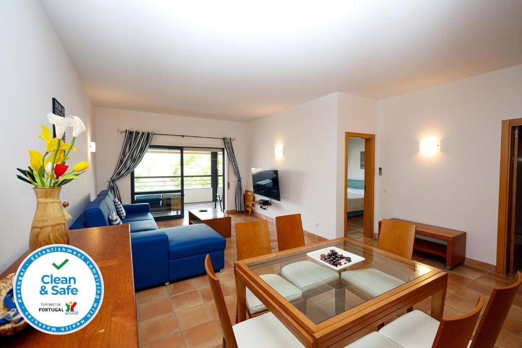 ein Wohnzimmer mit einem blauen Sofa und einem Tisch in der Unterkunft B39 - Marina Hill Apartment in Lagos