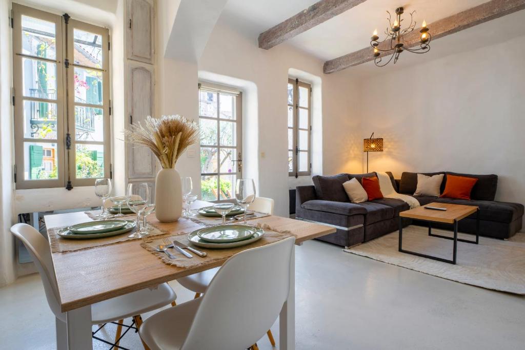 a dining room and living room with a table and chairs at L’oustaou de Ventabren Village Square in Ventabren