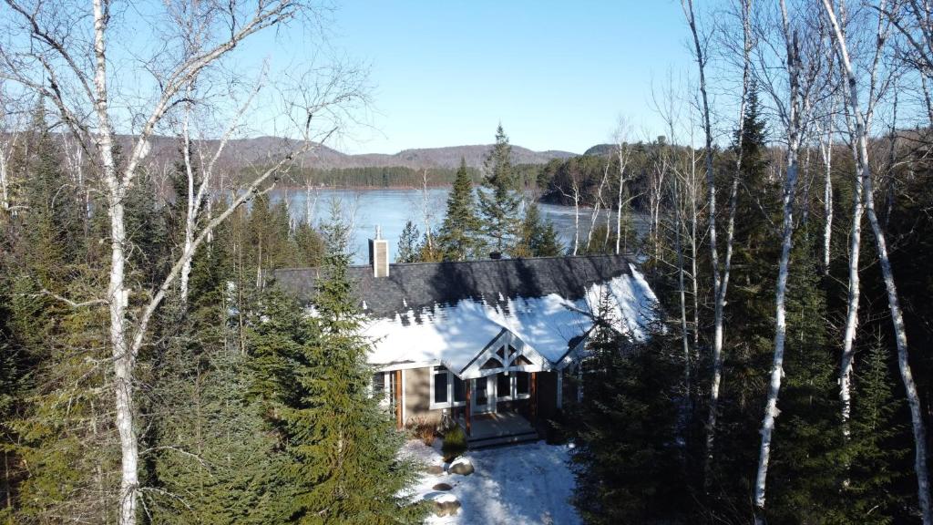 a house in the woods with snow on it at Spa and Lakeside - La Luz del Dia in Saint-Didace