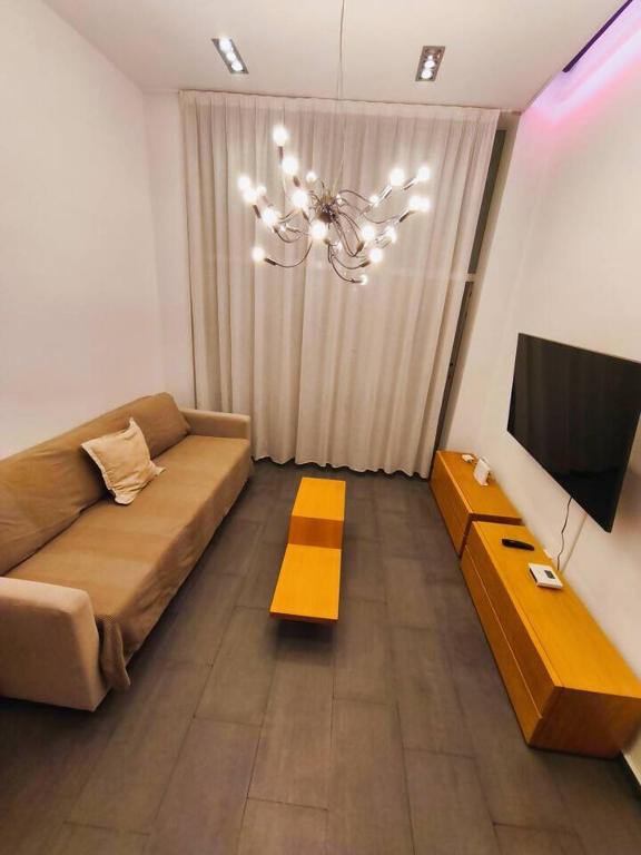 un salon avec un canapé et une télévision dans l'établissement Apartamento Loft Desing City Center, à Tolède