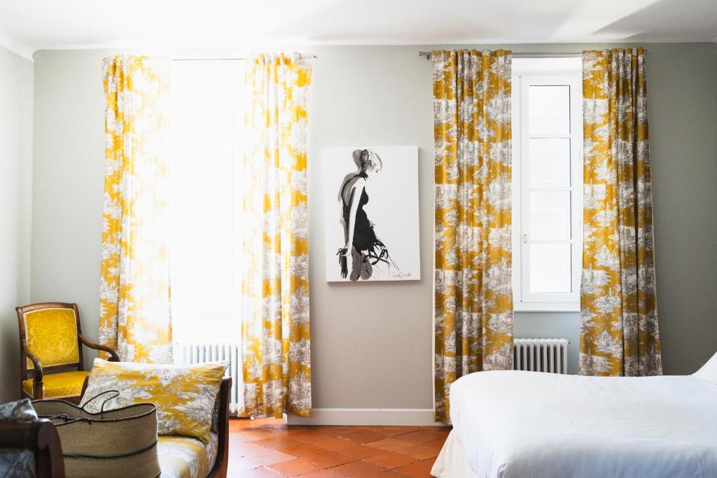 a bedroom with a bed and a window with curtains at Château de la Bousquetarie in Lempaut