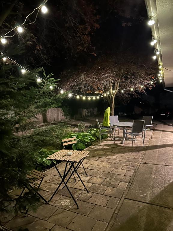 a patio with a table and chairs at night at Heera Apartmans in Hajdúszoboszló