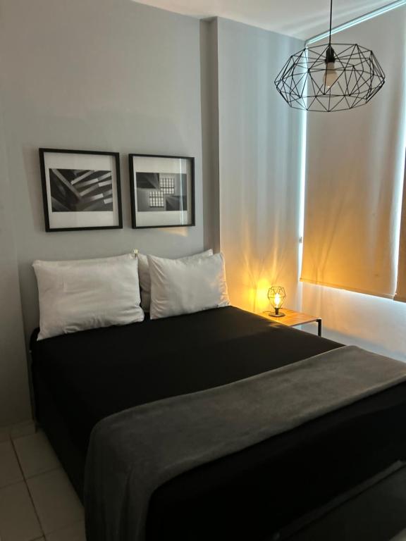 a bedroom with a large black bed and a window at Apartamento Frente ao Mar Santos II in Santos